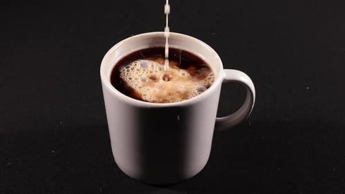 Cream Being Poured into a Mug of Coffee