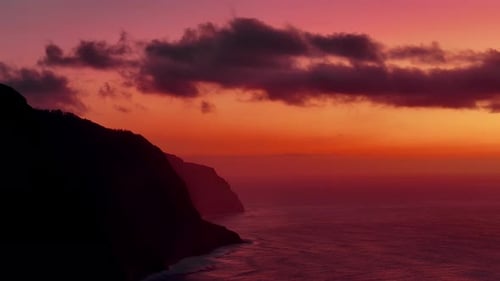 El faro se alza frente a la vibrante puesta de sol sobre el océano