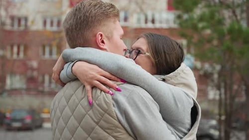 Young Couple Kissing and Embracing in City Setting
