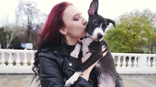 Woman Holds and Kisses Black and White Dog