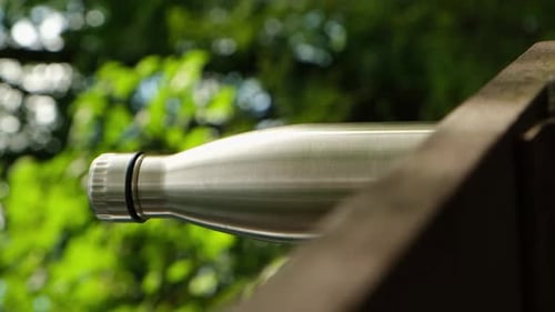 Metallic Water Bottle in Green Nature Setting