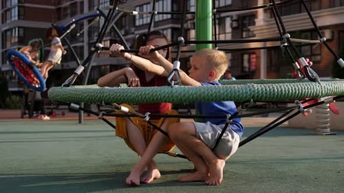 Children Climb the Grid on the Playground on a Hot Summer Day