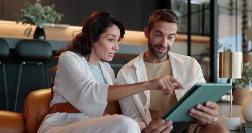 Man and Woman Looking at Tablet Together