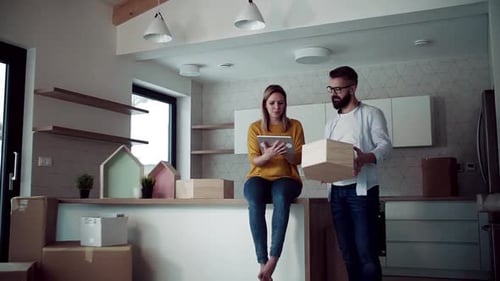 Couple Discussing Moving Boxes in New Home