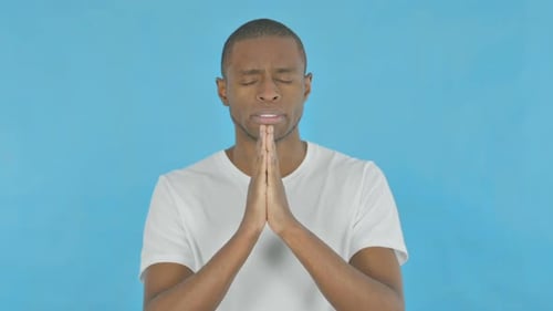 Afrikanischer Mann betet zu Gott auf blauem Hintergrund
