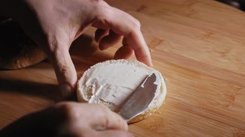 Preparing Burger Bun with Creamy White and Orange Sauce