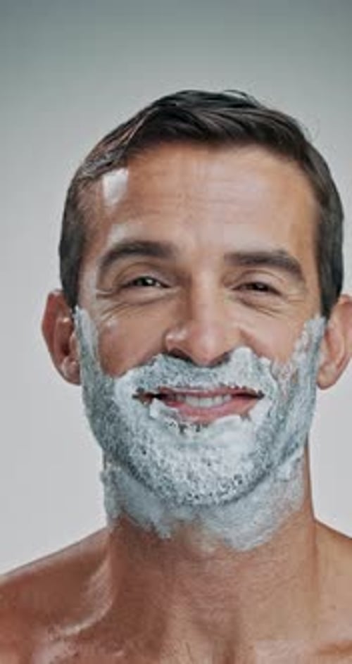 Happy man, face and beard with cream for shave, hair removal or epilation on a white studio