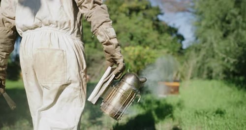 An unrecognizable male beekeeper working on his bee farm