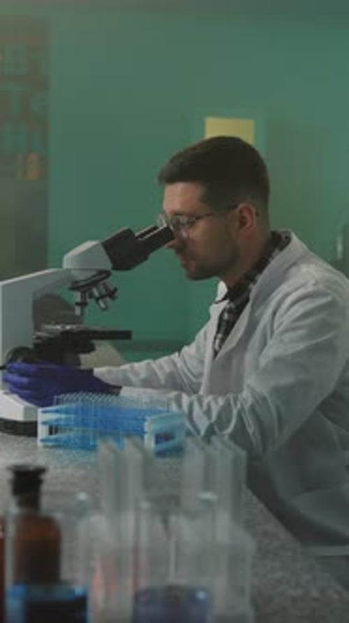 Scientists Doing Research with Microscope in Lab