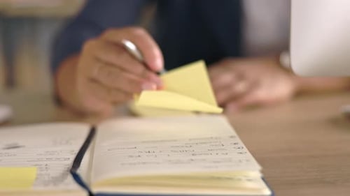Adult Putting Sticky Notes in Planner