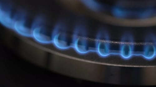 A Closeup of the Ignition of a Gas Stove Gas Burns with a Blue Flame in a Dark Room Vertical Video