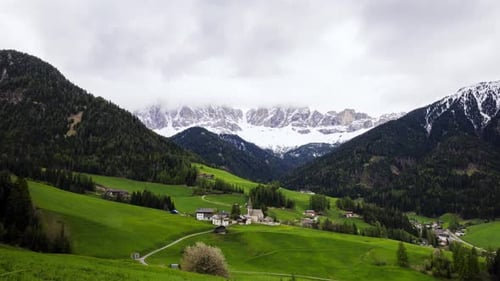 Malerisches Alpendorf zwischen Hügeln und Bergen in den Dolomiten