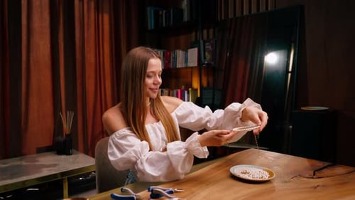 Young Adult Woman Making Beaded Jewelry at Home