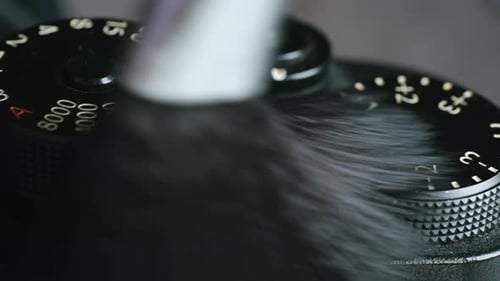 Photographer Wipes Down Professional Camera with Soft Brush