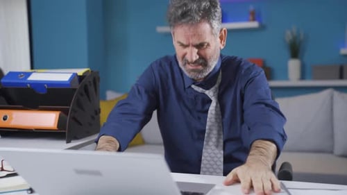 Stressed Man Working at Desk in Home Office