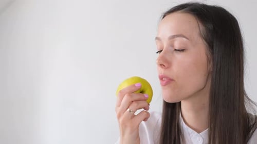 Young Woman Eating a Delicious Green Apple