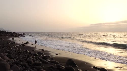 Idyllic scene of a woman relaxing unwinding at unspoiled virgin beach in summer at Spain