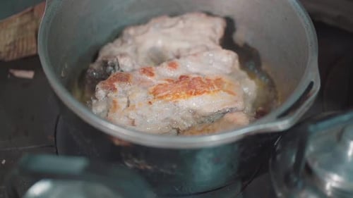 Pork strips browned in oil in a pot on a rural kitchen. Argentina. Close-up.