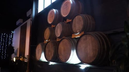 Barris de vinho empilhados através da parede de madeira em uma vinícola. de perto