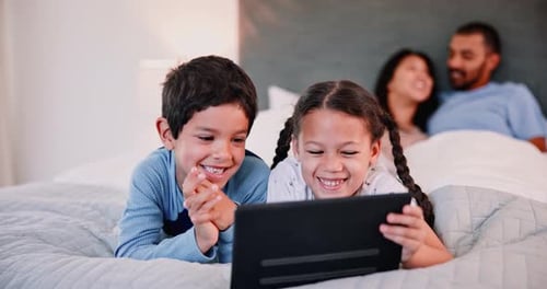 Children Using Tablet with Parents in Background