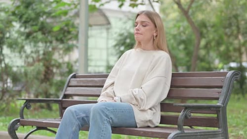 Woman Sitting and Waiting on a Bench