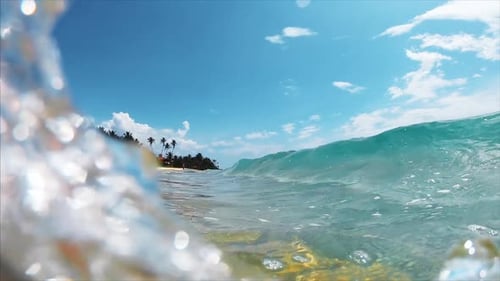 Ocean wave breaks over the sandy tropical beach
