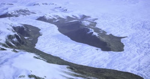 Paisagem montanhosa coberta de neve com características glaciais e vales no inverno