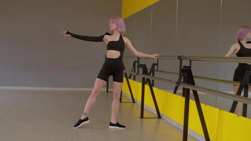 Woman Practicing Ballet at Barre in Dance Studio