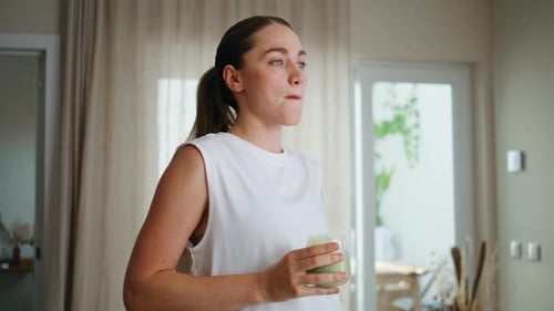 Woman Enjoys a Green Smoothie at Home