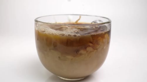 Milk Added to Coffee in Glass Cup
