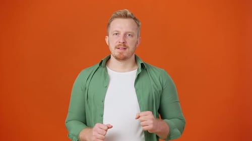 Man Speaking and Gesturing Against Orange Background