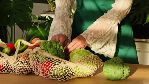 Mujer desempaqueta verduras y frutas de la bolsa