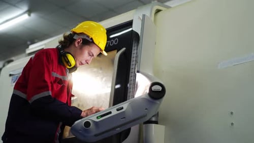 Factory Worker Operates Industrial Machine Controls