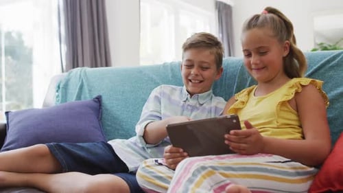 Happy Children Enjoying Tablet on Couch