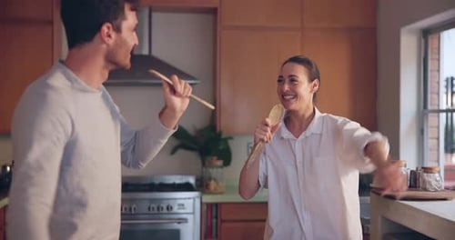 Couple Dancing Together with Spoons in Kitchen