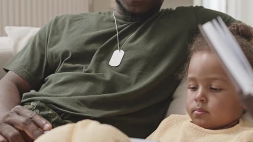 Man and Child Reading Book Together Indoors
