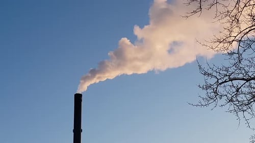 Massive Umweltverschmutzung durch Industrieschornsteine, isoliert von wunderschönem blauem Himmel