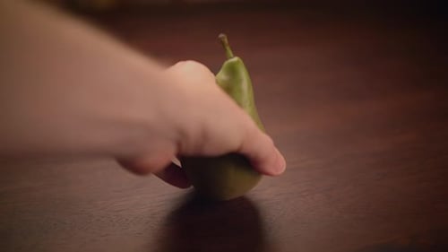 Green Pear Resting on a Wood Table