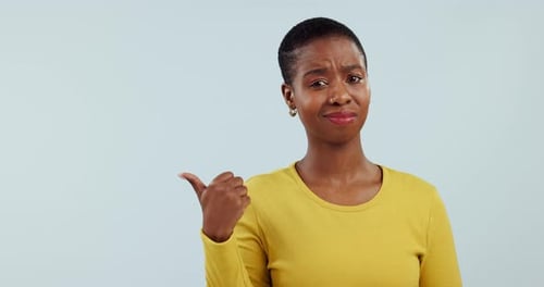 Confused, face and black woman with hand pointing in studio with fake news