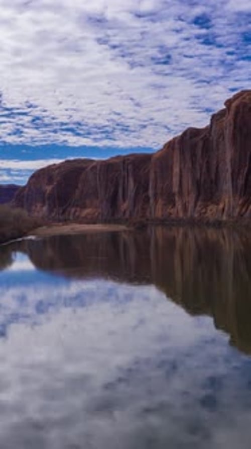 Colorado River and Red Sandstone Cliffs on Cloudy Day Utah USA Aerial View Vertical Video