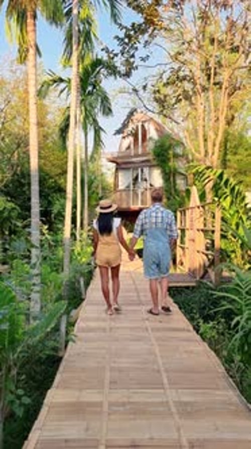 A Couple Strolls Hand in Hand Down a Nature Trail