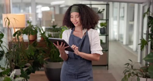 Young Adult Using Tablet Surrounded By Plants