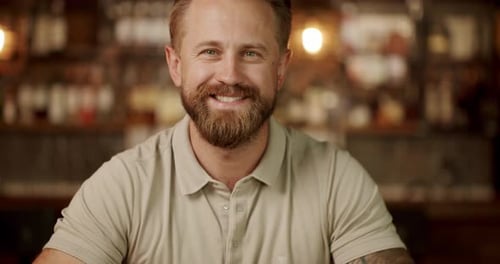 Smiling Bearded Man Poses Indoors in Restaurant