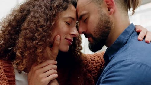Affectionate Couple Embracing with Foreheads Touching Indoors