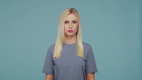 Jeune belle fille blonde dans le studio Portrait d'une fille émotionnelle sur fond bleu