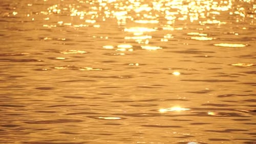 Blurred Golden Sea at Sunset The Sun Reflects and Sparkles on the Waves with Bokeh Illuminating the