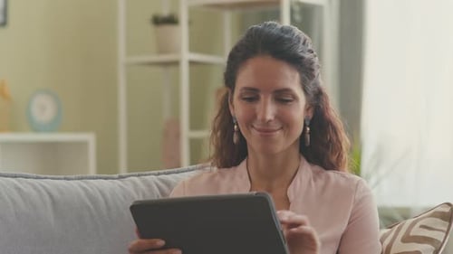 Woman Using Tablet on Couch in Living Room
