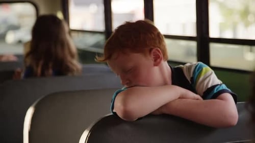 kids on the school bus - Red head crossed arms over seat