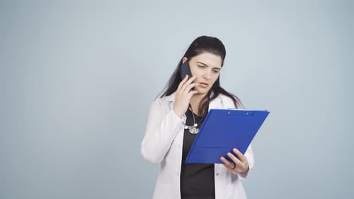 Doctor Consults Notes During Cell Phone Call
