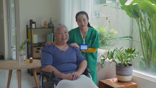 Senior Woman and Nurse Smiling Indoors